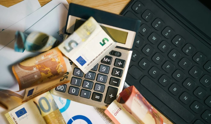 A calculator sitting on top of a pile of money